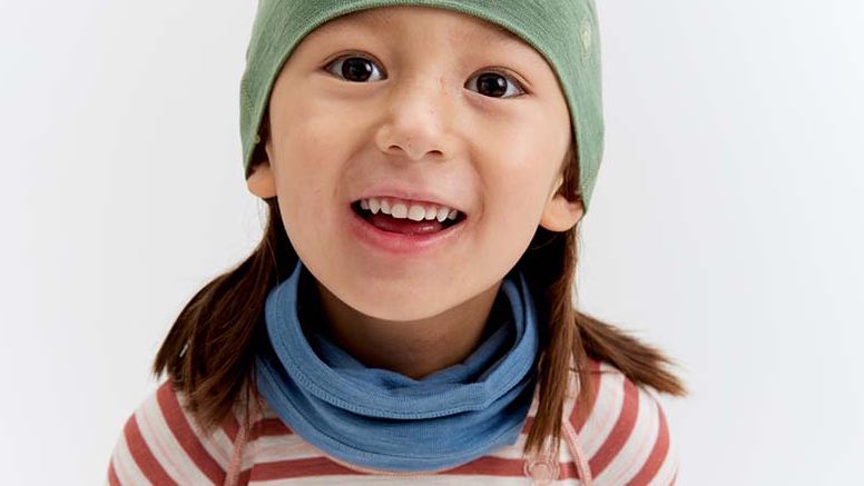 Bilde som viser et barn med lue, hals og trøye i merinoull.